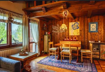 a dining room with a wooden table and chairs at Casa Mary in San Vito di Cadore