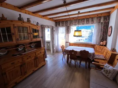 a dining room with a table and a window at casa Daria in Predazzo