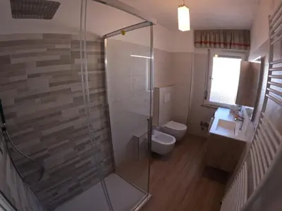 a bathroom with a shower and a toilet and a sink at casa Daria in Predazzo