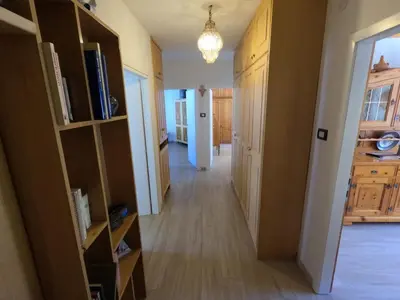 a hallway leading to a kitchen with wooden cabinets at casa Daria in Predazzo