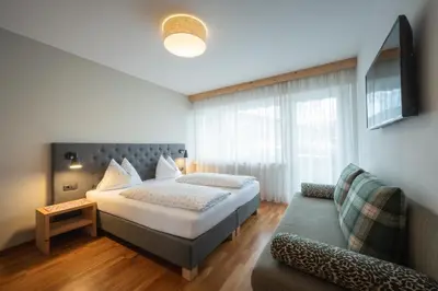 a hotel room with a bed and a couch at Haus Petra Mutschlechner in Riscone