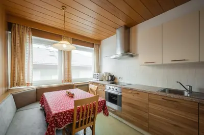 a kitchen with a table with a red table cloth on it at Haus Petra Mutschlechner in Riscone