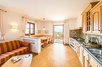 a kitchen and living room with a couch and a table at Ansitz Mair im Korn in Lagundo