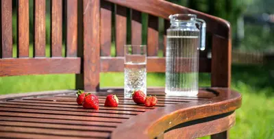 a table with strawberries and a bottle of water on it at Ansitz Mair im Korn in Lagundo