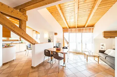 a kitchen and living room with a wooden ceiling at Ansitz Mair im Korn in Lagundo