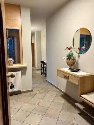 a hallway with a mirror and a vase on a table at Apartment Martha in Sankt Leonhard in San Leonardo in Passiria