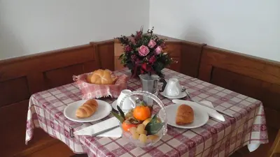 a table with plates of bread and a basket of fruit at Cèsa Raggio di Sole in Arabba