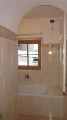 a bathroom with a tub and a window at Cèsa Raggio di Sole in Arabba