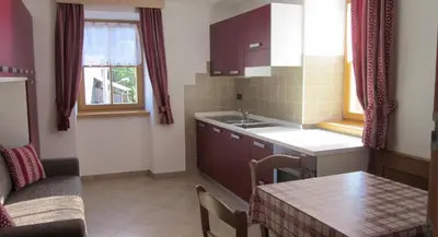 a small kitchen with a table and a couch at Cèsa Raggio di Sole in Arabba