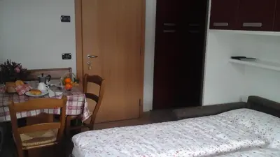 a room with a table and a table and a bed at Cèsa Raggio di Sole in Arabba