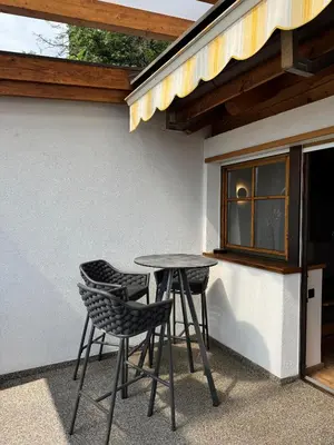 a patio table and chairs next to a building at Törggelehof Lana in Lana