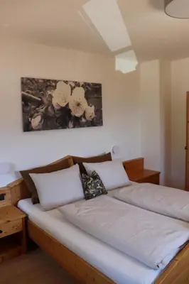 a bed with two pillows on it in a room at Törggelehof Lana in Lana