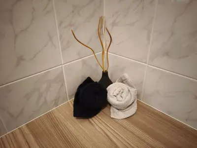 a black vase sitting on a counter with towels at Törggelehof Lana in Lana