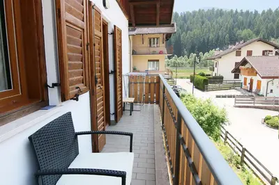 a balcony with a bench and a view of a street at Casa Virginia in Val di Fiemme in Castello di Fiemme