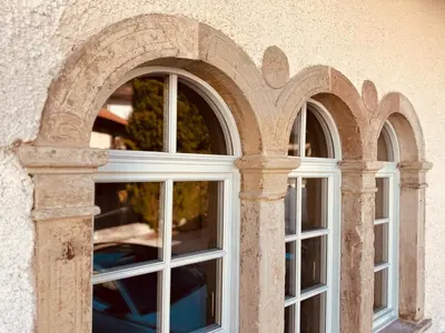 three windows in a building with arches at Zum Nussbaum in Termeno