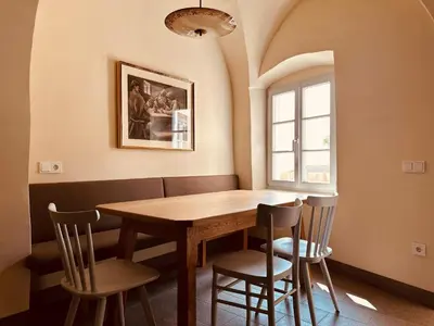 a dining room with a wooden table and chairs at Zum Nussbaum in Termeno