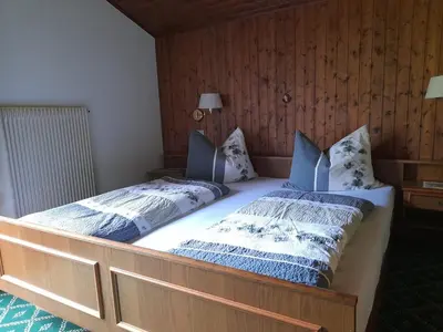 a bedroom with two beds with blue and white pillows at Haus Alpenheim in Braies
