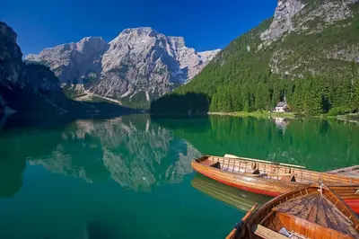 two boats on a lake in front of a mountain at Haus Alpenheim in Braies