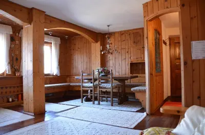 a dining room with a table and chairs and wooden walls at Crepedel in Cortina dʼAmpezzo