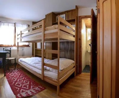 a bedroom with two bunk beds in a room at Crepedel in Cortina dʼAmpezzo