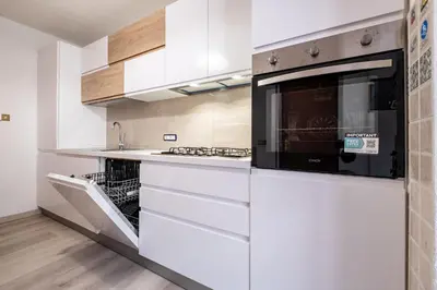 a kitchen with white cabinets and a microwave at Casa Quinta by Go New Location in Predazzo