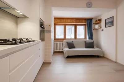 a kitchen with a stove and a chair in a room at Casa Quinta by Go New Location in Predazzo