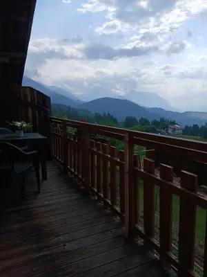 a wooden deck with a view of the mountains at Maso Solandro in Solaiolo