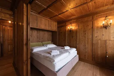 a bedroom with a bed in a wooden room at Casa Verocai, graziosi bilocali in centro a Cortina in Cortina dʼAmpezzo