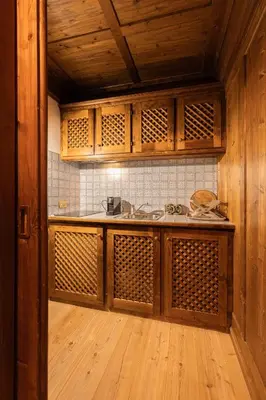 a kitchen with wooden cabinets and a sink at Casa Verocai, graziosi bilocali in centro a Cortina in Cortina dʼAmpezzo