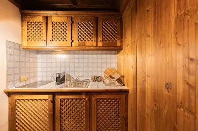 a kitchen with wooden cabinets and a sink at Casa Verocai, graziosi bilocali in centro a Cortina in Cortina dʼAmpezzo