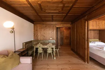 a room with a table and chairs and a bed at Casa Verocai, graziosi bilocali in centro a Cortina in Cortina dʼAmpezzo