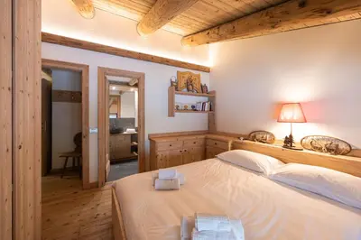 a bedroom with a large bed in a room at Casa Verocip, with panoramic balcony on Dolomites in Cortina dʼAmpezzo