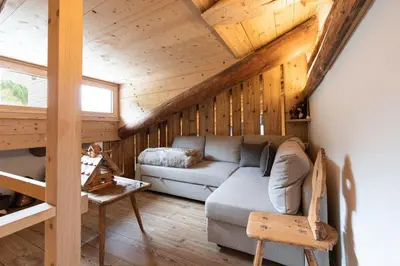 a living room with a couch and a wooden ceiling at Casa Verocip, with panoramic balcony on Dolomites in Cortina dʼAmpezzo