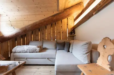 a living room with a couch and wooden ceilings at Casa Verocip, with panoramic balcony on Dolomites in Cortina dʼAmpezzo