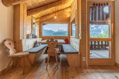 a wooden cabin with a bench and a window at Casa Verocip, with panoramic balcony on Dolomites in Cortina dʼAmpezzo