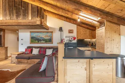 a kitchen and living room with a couch in a room at Casa Verocip, with panoramic balcony on Dolomites in Cortina dʼAmpezzo