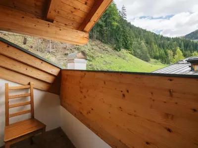 a wooden room with a wooden chair and a window at Apartment Erika by Interhome in Canazei