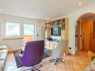a living room with two chairs and a tv at Apartment Erika by Interhome in Canazei