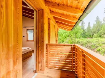 a wooden cabin with a balcony with a bed on it at Villa Casa del Larice by Interhome in Livo