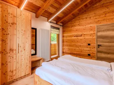 a bedroom with a bed in a wooden room at Villa Casa del Larice by Interhome in Livo
