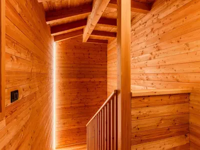 a wooden staircase in a log cabin with wooden walls at Villa Casa del Larice by Interhome in Livo