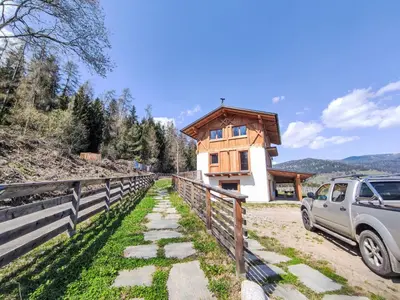a car parked in front of a wooden house at Villa Casa del Larice by Interhome in Livo