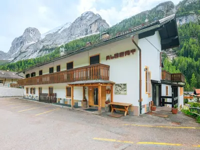 a building with a bench in front of a mountain at Apartment Albert by Interhome in Penia