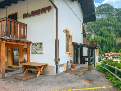 a building with a wooden picnic table outside of it at Apartment Albert by Interhome in Penia