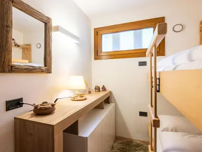 a bedroom with a desk and a bunk bed at Apartment Casa Morelli by Interhome in Pozza di Fassa