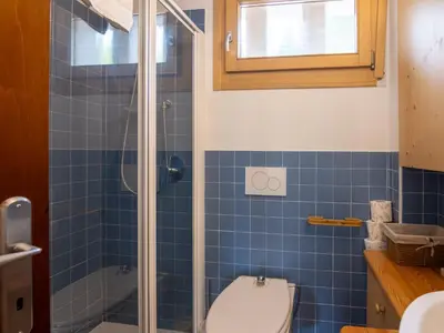 a blue tiled bathroom with a toilet and a shower at Apartment Casa Morelli by Interhome in Pozza di Fassa