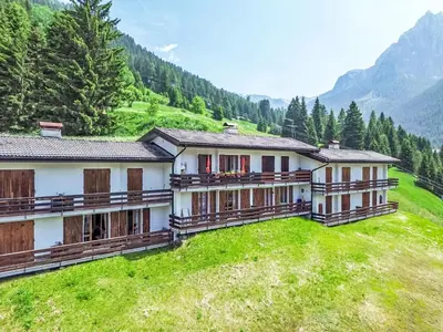 a group of buildings on a hill with mountains at Apartment Casa Morelli by Interhome in Pozza di Fassa