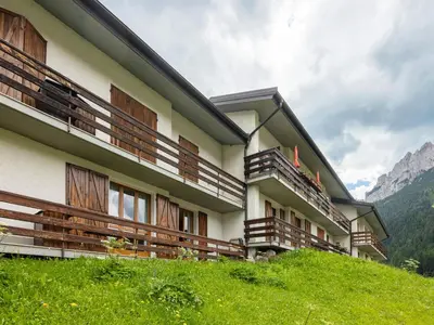 a building with wooden balconies on top of a hill at Apartment Casa Morelli by Interhome in Pozza di Fassa