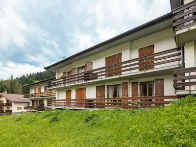 a building with wooden balconies on the side of it at Apartment Casa Morelli by Interhome in Pozza di Fassa