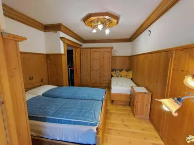 a bedroom with a bed in a room with wooden walls at Appartamento Bill Sottoguda in Sottoguda